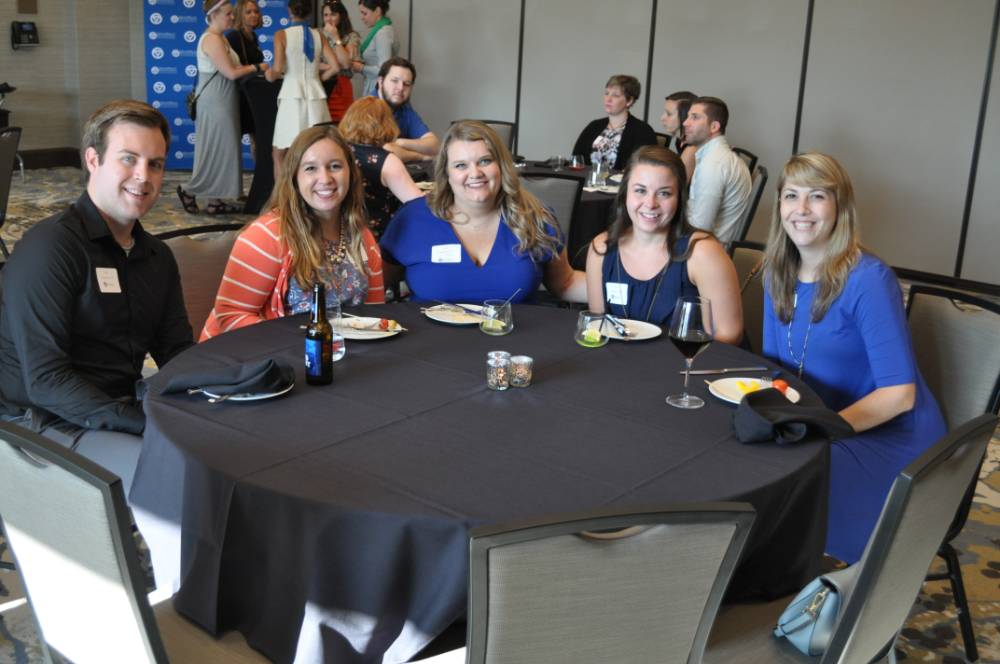5 alumni sit at event table